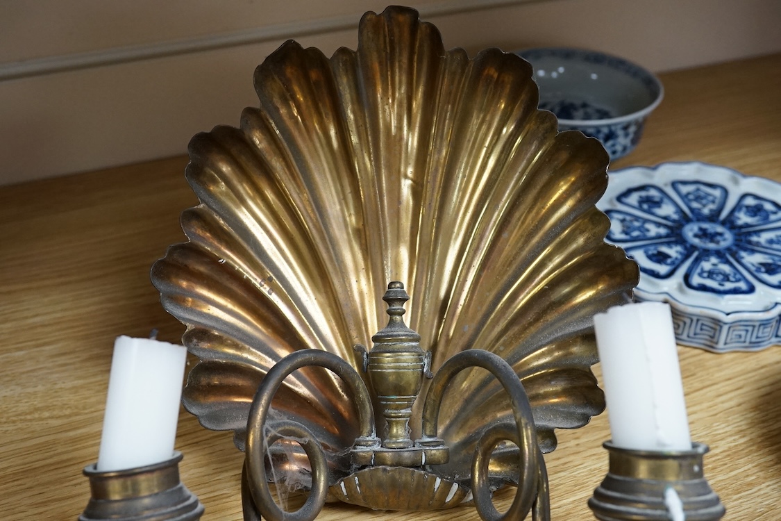 A pair of brass twin branch wall lights with scallop shell backs, 26cm high